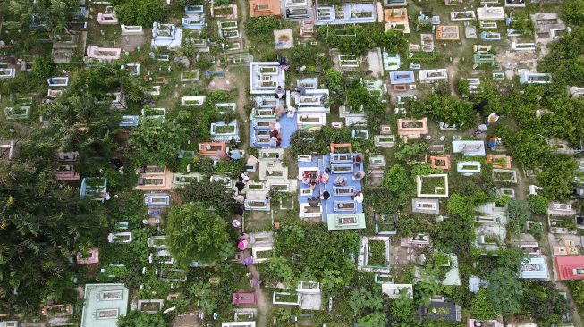 Foto udara warga menziarahi makam kerabatnya di TPU Pogego, Palu, Sulawesi Tengah, Minggu (10/7/2022). ANTARA FOTO/Mohamad Hamzah
