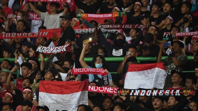 Para suporter Timnas Indonesia U-19 meneriakkan yel yel di Stadion Patriot, Bekasi, Minggu (10/7/2022) malam. [ANTARA FOTO/Akbar Nugroho Gumay]