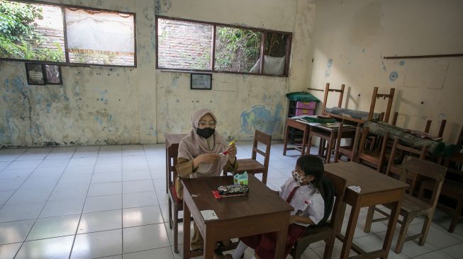 Guru mengajar seorang siswa di SD Negeri Sriwedari 197 Solo, Jawa Tengah, Senin (11/7/2022). ANTARA FOTO/Mohammad Ayudha