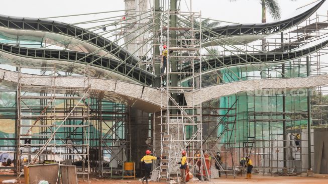 Pekerja beraktivitas di proyek revitalisasi Taman Mini Indonesia Indah (TMII), Jakarta Timur, Selasa (12/7/2022). [Suara.com/Alfian Winanto]
