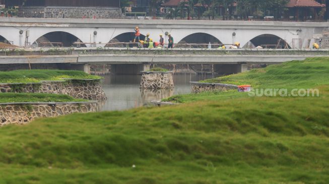 Pekerja beraktivitas di proyek revitalisasi Taman Mini Indonesia Indah (TMII), Jakarta Timur, Selasa (12/7/2022). [Suara.com/Alfian Winanto]
