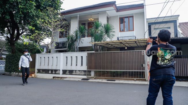 Seorang jurnalis melakukan peliputan di depan rumah dinas Kadiv Propam Polri Irjen Pol Ferdy Sambo di Kompleks Polri DUren Tiga, Jakarta Selatan, Rabu (13/7/2022). [Suara.com/Alfian Winanto]