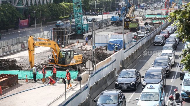 Pekerja menyelesaikan proyek Moda Raya Terpadu (MRT) Fase II di Jalan MH Thamrin, Jakarta Pusat, Kamis (14/7/2022). [Suara.com/Alfian Winanto]