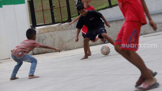 Anak-anak bermain bola di Trotoar Taman Ismail Marzuki, Kamis, Jakarta (14/7).  [Suara.com/Oke Atmaja]
