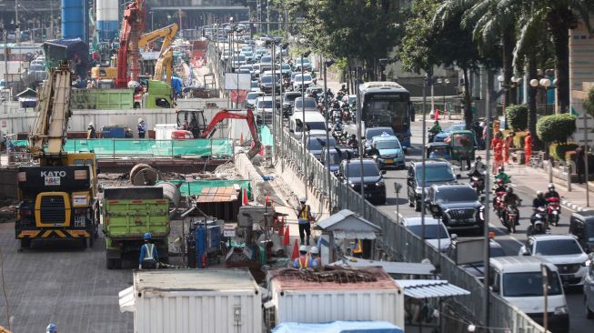 Pekerja menyelesaikan proyek Moda Raya Terpadu (MRT) Fase II di Jalan MH Thamrin, Jakarta Pusat, Kamis (14/7/2022). [Suara.com/Alfian Winanto]