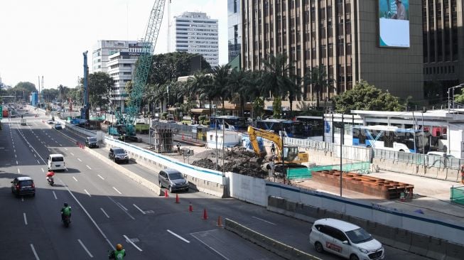 Pekerja menyelesaikan proyek Moda Raya Terpadu (MRT) Fase II di Jalan MH Thamrin, Jakarta Pusat, Kamis (14/7/2022). [Suara.com/Alfian Winanto]