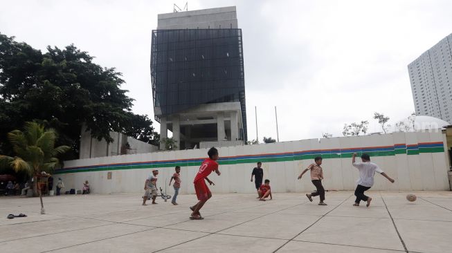 Anak-anak bermain bola di Trotoar Taman Ismail Marzuki, Kamis, Jakarta (14/7).  [Suara.com/Oke Atmaja]
