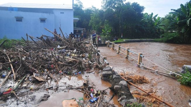 Warga melihat sampah yang menyumbat Sungai Dawe di Desa Golantepus, Mejobo, Kudus, Jawa Tengah, Kamis (14/7/2022). ANTARA FOTO/Yusuf Nugroho