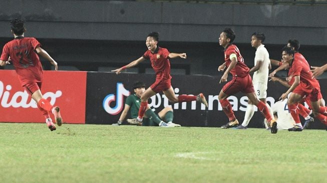 Pesepak bola Timnas Laos U-19 melakukan selebrasi usai Bukkoree Lemdee (tengah) mencetak gol ke gawang Timnas Thailand U-19 dalam laga semifinal Piala AFF U19 2022 di Stadion Patriot Chandrabhaga, Bekasi, Jawa Barat, Rabu (13/7/2022).  [Antara Foto]