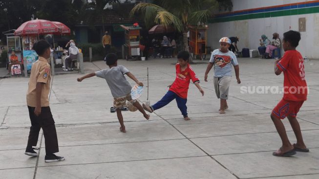 Anak-anak bermain bola di Trotoar Taman Ismail Marzuki, Kamis, Jakarta (14/7).  [Suara.com/Oke Atmaja]
