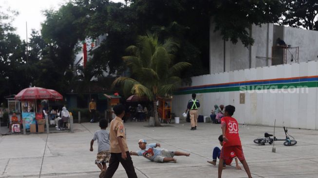 Anak-anak bermain bola di Trotoar Taman Ismail Marzuki, Kamis, Jakarta (14/7).  [Suara.com/Oke Atmaja]
