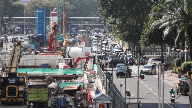 Pekerja menyelesaikan proyek Moda Raya Terpadu (MRT) Fase II di Jalan MH Thamrin, Jakarta Pusat, Kamis (14/7/2022). [Suara.com/Alfian Winanto]