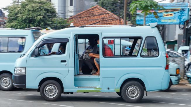 Angkutan Umum yang membawa penumpang melintas di Jalan Raya Jatinegara Barat, Jakarta Timur, Jumat (15/7/2022). [Suara.com/Alfian Winanto]