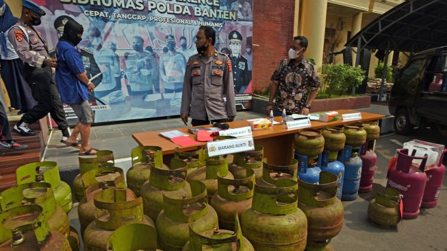 Polisi menggiring tersangka penyalahgunaan gas LPG bersubsidi berinisial MU (kedua kiri) saat ekspos di Mapolda Banten, di Serang, Jumat (15/7/2022).  ANTARA FOTO/Asep Fathulrahman