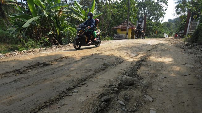 Warga mengendarai motor melintasi jalan desa yang rusak di Bayat, Klaten, Jawa Tengah, Jumat (15/7/2022). ANTARA FOTO/Aloysius Jarot Nugroho