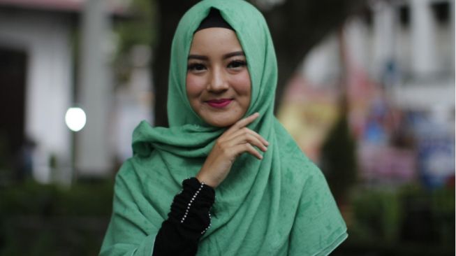 ilustrasi seorang perempuan sedang menggunakan jilbab(Pixabay/Ratna_Fitri)