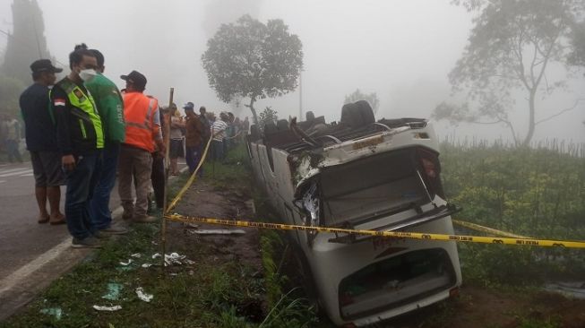 Bus Tama Holiday mengangkut penumpang rombongan pendaki asal Jakarta dan Bogor, terguling di jalur menanjak Desa Ketep, Magelang, Sabtu (16/7/2022). (Suara.com/ Angga Haksoro Ardi).  