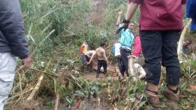  Sejumlah petugas saat mengevakuasi jenazah yang terbawa longsor di area pemakaman Cianjur [Ist]