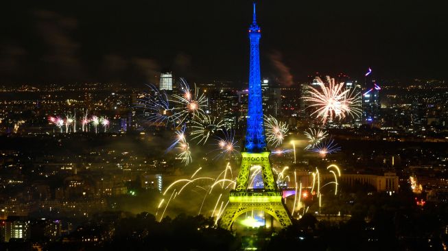 Kembang api menerangi Menara Eiffel saat perayaan Hari Bastille di Paris, Prancis, Kamis (14/7/2022). [Geoffroy Van der Hasselt / AFP]