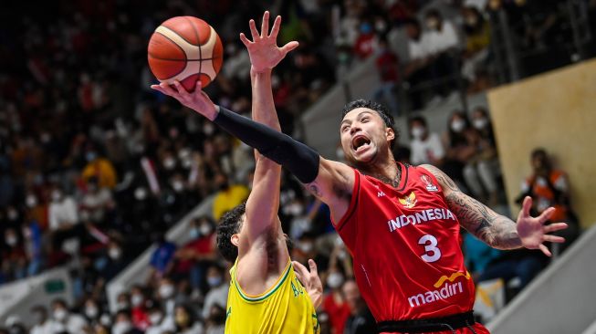 Pebasket Indonesia Brandon Van Dom Jawato (kanan) melakukan lay up melewati pebasket Australia Samuel Mcdaniel (kiri) dalam babak penyisihan Grup A FIBA Asia Cup 2022 di Istora Gelora Bung Karno, Senayan, Jakarta, Sabtu (16/7/2022). [ANTARA FOTO/Galih Pradipta/wsj]
