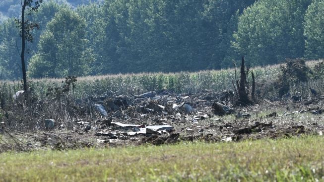 Puing-puing milik pesawat kargo Antonov An-12 yang jatuh terlihat di Desa Palaiochoro, kota Kavala, Yunani, Minggu (17/7/2022). [Sakis MITROLIDIS / AFP]