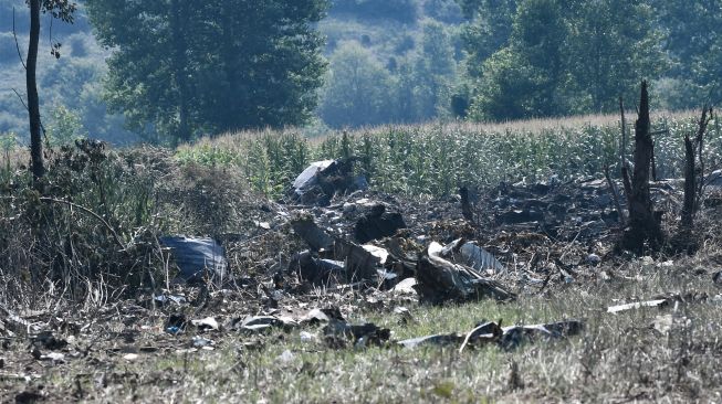 Puing-puing milik pesawat kargo Antonov An-12 yang jatuh terlihat di Desa Palaiochoro, kota Kavala, Yunani, Minggu (17/7/2022). [Sakis MITROLIDIS / AFP]