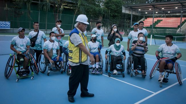 Menteri Pekerjaan Umum dan Perumahan Rakyat Basuki Hadimuljono (depan) bersama atlet tenis kursi roda mengecek kesiapan Lapangan Tenis Manahan, Solo, Jawa Tengah, Sabtu (16/7/2022). [ANTARA FOTO/Mohammad Ayudha/wsj]