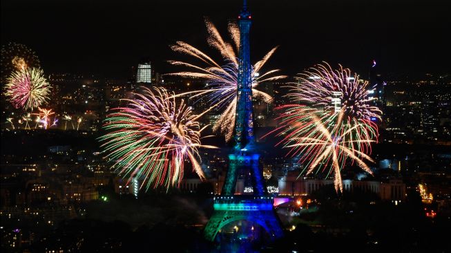 Kembang api menerangi Menara Eiffel saat perayaan Hari Bastille di Paris, Prancis, Kamis (14/7/2022). [Geoffroy Van der Hasselt / AFP]