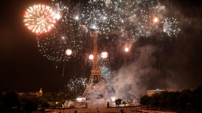 Kembang api menerangi Menara Eiffel saat perayaan Hari Bastille di Paris, Prancis, Kamis (14/7/2022). [Geoffroy Van der Hasselt / AFP]