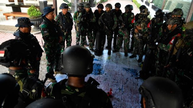 Direktur Operasi Puskopaska Kolonel Laut (P) Johan Wahyudi (kedua kiri) bersama Komandan Satuan Tugas Peperangan Laut Khusus Letkol Laut (P) Sadarianto (kiri) serta Wakil Komandan Satuan Tugas Peperangan Laut Khusus Mayor Laut (S) Mulya Abadi (ketiga kiri) memberikan pengarahan rencana operasi kepada prajurit Kopaska di kawasan Pantai Pasir Putih Banongan, Situbondo, Jawa Timur, Sabtu (16/7/2022). [ANTARA FOTO/Zabur Karuru]