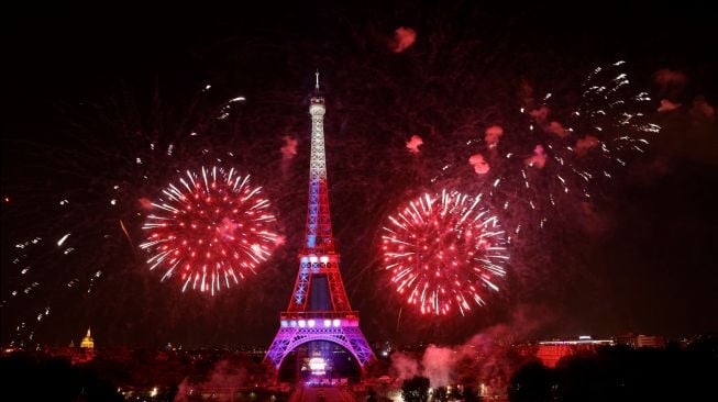 Kembang api menerangi Menara Eiffel saat perayaan Hari Bastille di Paris, Prancis, Kamis (14/7/2022). [Geoffroy Van der Hasselt / AFP]