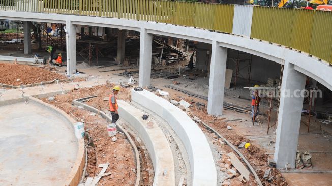 Pekerja menyelesaikan proyek revitalisasi Taman Martha Tiahahu di kawasan Blok M, Jakarta Selatan, Selasa (19/7/2022). [Suara.com/Alfian Winanto]