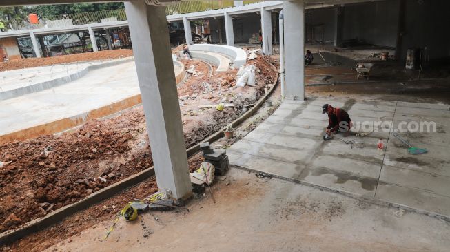 Pekerja menyelesaikan proyek revitalisasi Taman Martha Tiahahu di kawasan Blok M, Jakarta Selatan, Selasa (19/7/2022). [Suara.com/Alfian Winanto]