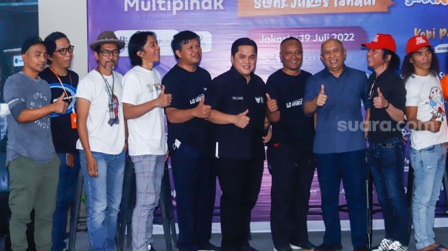 Menteri BUMN Erick Thohir (keenam kiri), Menteri Koperasi dan UKM Teten Masduki (ketiga kanan) bersama grup band Slank dan para Slankers saat launching koperasi Slankops di Jalan Potlot, Jakarta Selatan, Selasa (19/7/2022). [Suara.com/Alfian Winanto]