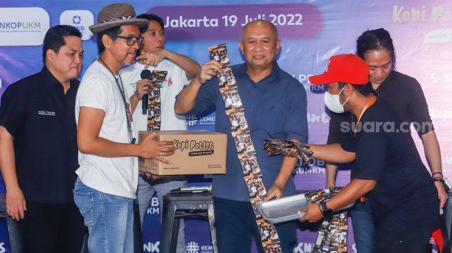 Personil grup band Slank Ridho memberi kopi Potlot kepada Menteri Korupsi dan UKM saat launching koperasi Slankops di Jalan Potlot, Jakarta Selatan, Selasa (19/7/2022). [Suara.com/Alfian Winanto]