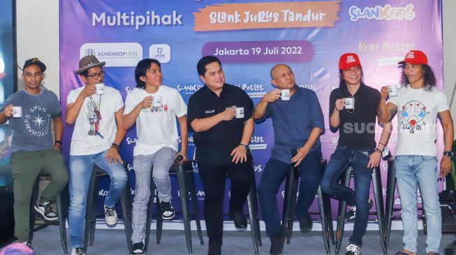 Menteri BUMN Erick Thohir (keempat kiri), Menteri Koperasi dan UKM Teten Masduki (ketiga kanan) bersama grup band Slank meminum kopi saat launching koperasi Slankops di Jalan Potlot, Jakarta Selatan, Selasa (19/7/2022). [Suara.com/Alfian Winanto]