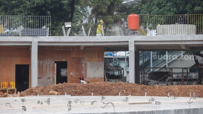 Pekerja menyelesaikan proyek revitalisasi Taman Martha Tiahahu di kawasan Blok M, Jakarta Selatan, Selasa (19/7/2022). [Suara.com/Alfian Winanto]