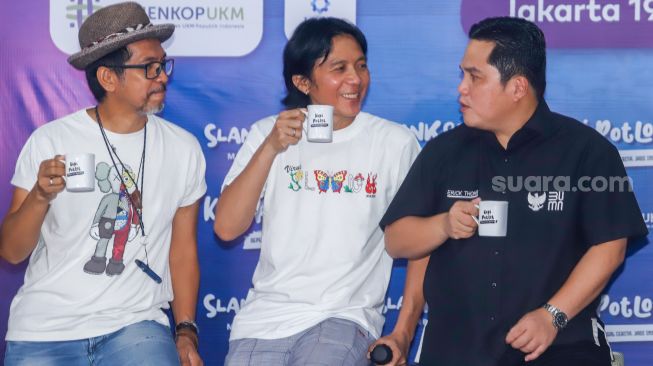 Menteri BUMN Erick Thohir (kanan) bersama personil grup band Slank Bimbim (tengah) dan Ridho (kiri) saat launching koperasi Slankops di Jalan Potlot, Jakarta Selatan, Selasa (19/7/2022). [Suara.com/Alfian Winanto]