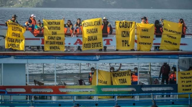 Aktivis perempuan membentangkan spanduk raksasa di Danau Toba. [greenpeace]