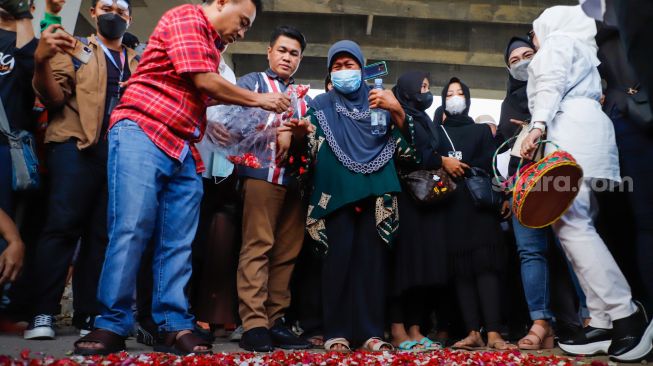 Keluarga korban dan warga sekitar saat menggelar aksi tabur bunga di Jalan Transyogi Cibubur, Bekasi, Jawa Barat, Rabu (20/7/2022). [Suara.com/Alfian Winanto]