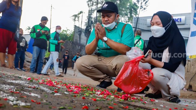 Keluarga korban dan warga sekitar saat menggelar aksi tabur bunga di Jalan Transyogi Cibubur, Bekasi, Jawa Barat, Rabu (20/7/2022). [Suara.com/Alfian Winanto]