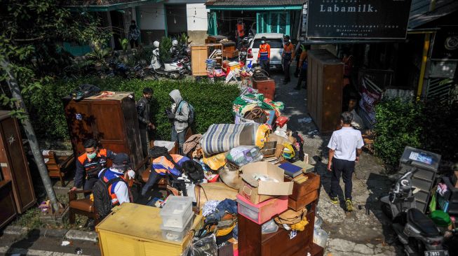 Petugas mengeluarkan barang dari dalam rumah saat penertiban aset milik PT KAI di Jalan Laswi, Bandung, Jawa Barat, Rabu (20/7/2022).  ANTARA FOTO/Raisan Al Farisi
