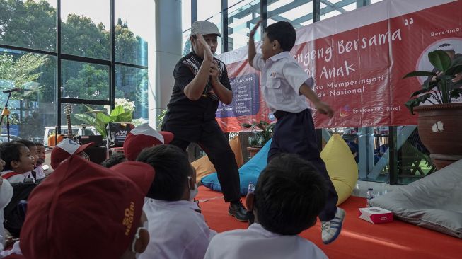 Seorang pendongeng berinteraksi dengan sejumlah murid TK dan SD saat acara Mendongeng Bersama 1001 Anak di Stasiun Purwokerto, Banyumas, Jawa Tengah, Kamis (21/7/2022). ANTARA FOTO/Idhad Zakaria
