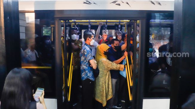 Penumpang menaiki bus TransJakarta di Halte Tosari, Jakarta Pusat, Kamis (21/7/2022). [Suara.com/Alfian Winanto]