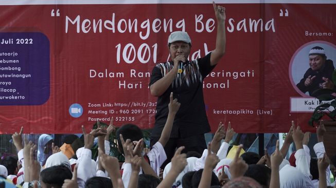 Seorang pendongeng mendongeng di depan sejumlah murid TK dan SD saat acara Mendongeng Bersama 1001 Anak di Stasiun Purwokerto, Banyumas, Jawa Tengah, Kamis (21/7/2022).  ANTARA FOTO/Idhad Zakaria