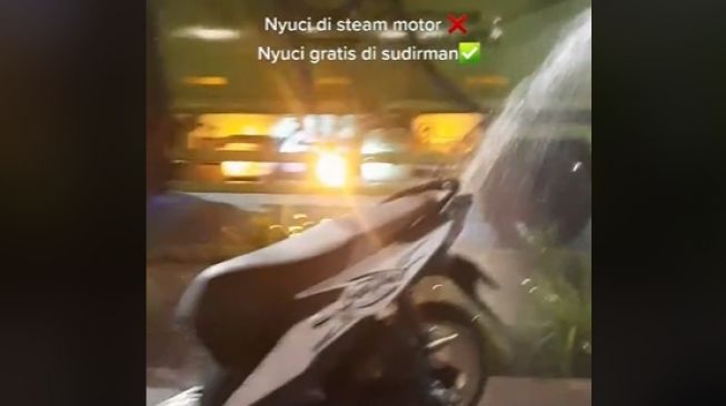 Motor dicuci gratis oleh petugas penyiram tanaman saat parkir di pinggir jalan (Instagram)