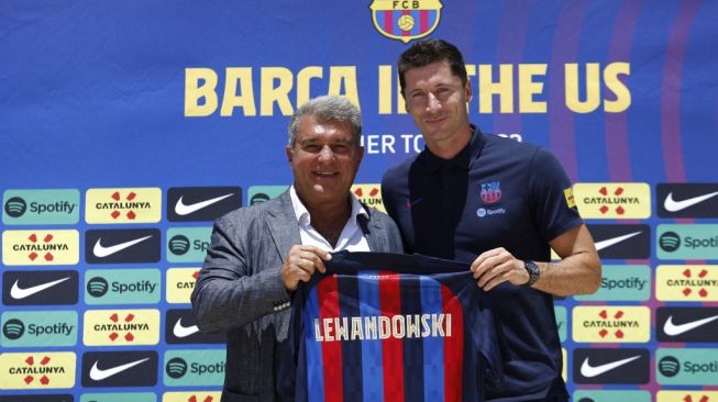 Penyerang baru Barcelona, Robert Lewandowski (kanan) dan Presiden Barcelona Juan Laporta. [MARCO BELLO / AFP]