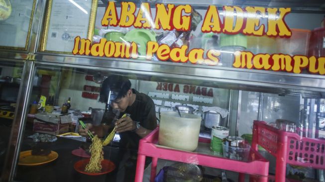 Pekerja merapikan mi instan kemasan di Warung Abang Adek, Jakarta, Kamis (21/7/2022).  ANTARA FOTO/Rivan Awal Lingga