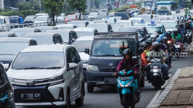 Sejumlah kendaraan bermotor melintas di Jalan MT Haryono, Jakarta Timur, Kamis (21/7/2022). [Suara.com/Alfian Winanto]