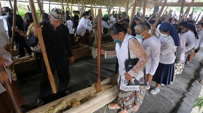 Warga menumbuk padi bersama saat perayaan adat Seren taun di Cigugur, Kuningan, Jawa Barat, Jumat (22/7/2022). ANTARA FOTO/Dedhez Anggara
